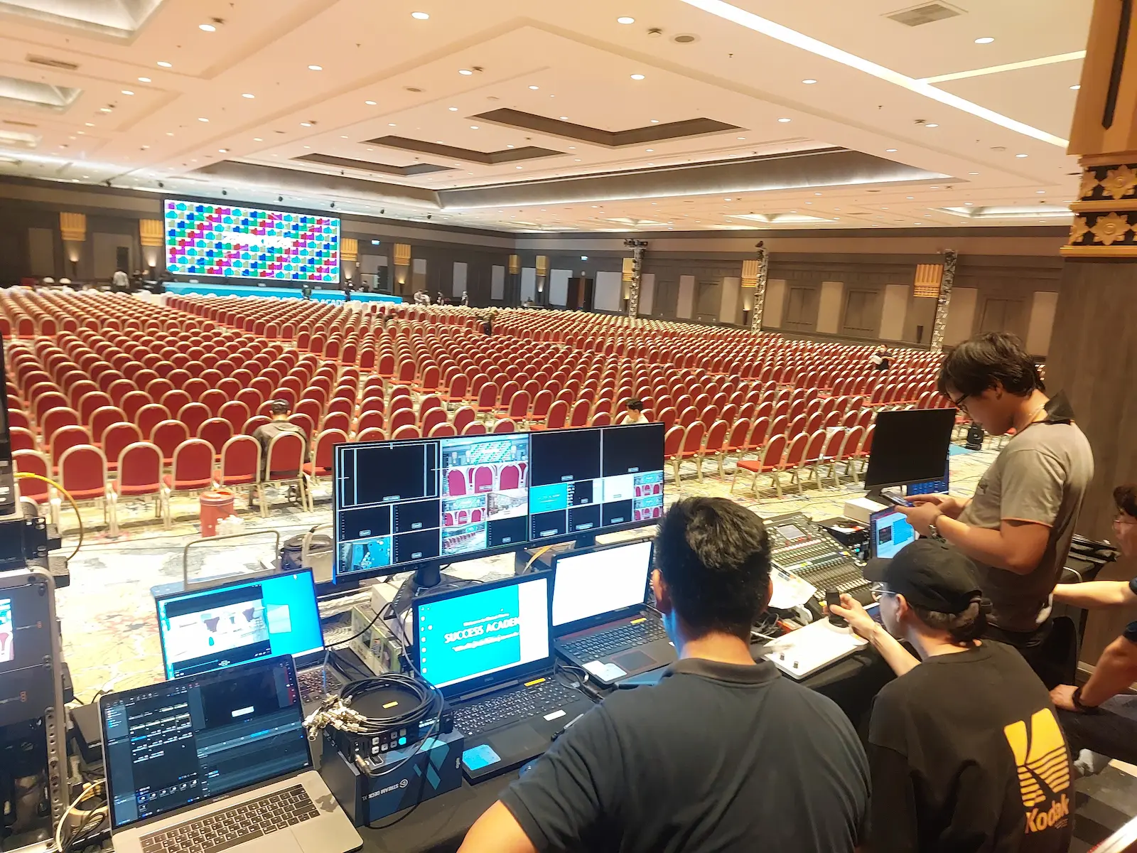 มุมมองจากเจ้าหน้าที่ควบคุมระบบภาพ (Vision Mixer) ดูแลการสลับภาพขึ้นจอ LED สด ท่ามกลางฮอลล์งานสัมมนาสเกลใหญ่