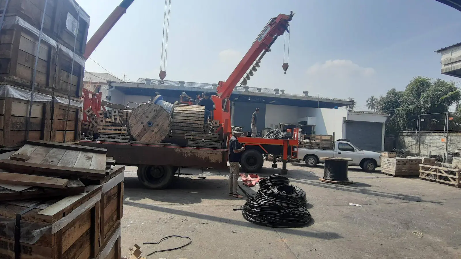 การยกม้วนสายเคเบิลแรงสูงขึ้นรถเครน เพื่อเตรียมงานเดินสายไฟฟ้า